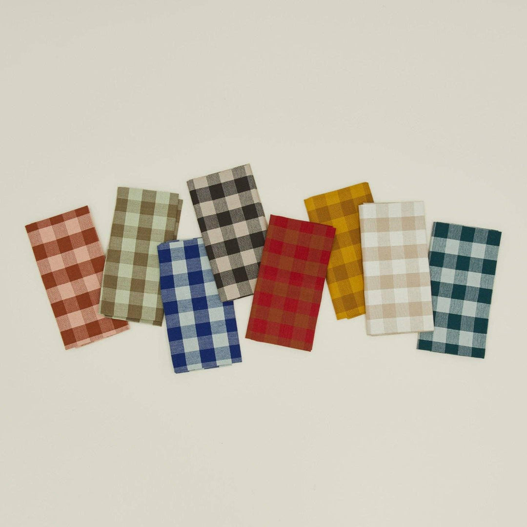 Set of plaid napkins in various colors on a beige background