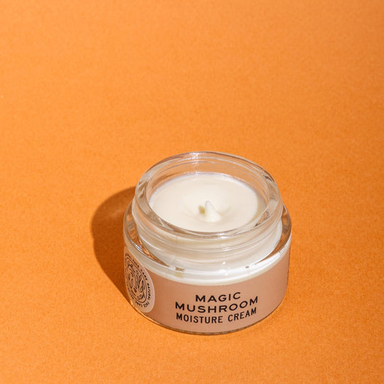 Jar of 'Magic Mushroom Moisture Cream' on an orange background