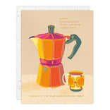 Greeting card with a colorful illustration of a coffee maker and a cup, featuring text about an anniversary.