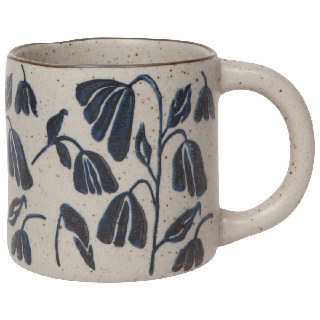 Ceramic mug with blue leaf patterns on a white background