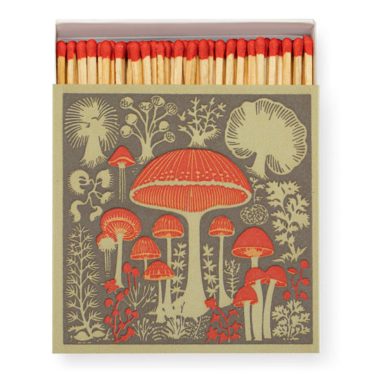 a box of matched that has a picture of red and cream mushrooms on a brown background.