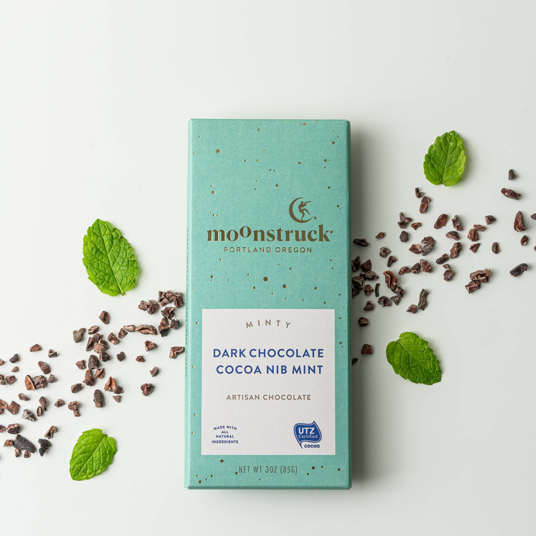 moOnstruck dark chocolate cocoa nib mint bar with mint leaves on a white background