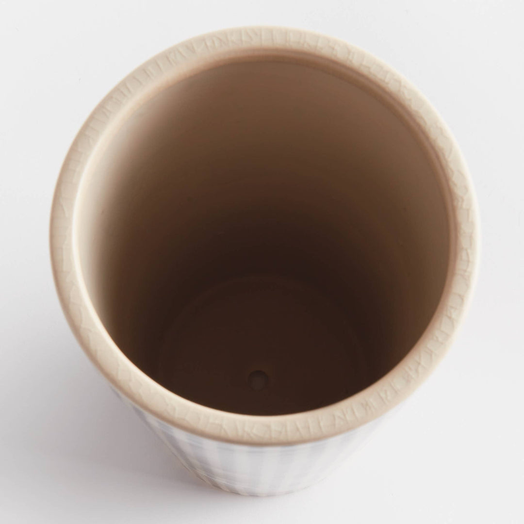 Close-up of a brown ceramic cup on a white background