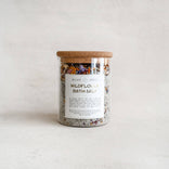Jar of Wildflower Bath Salt with a wooden lid on a light background