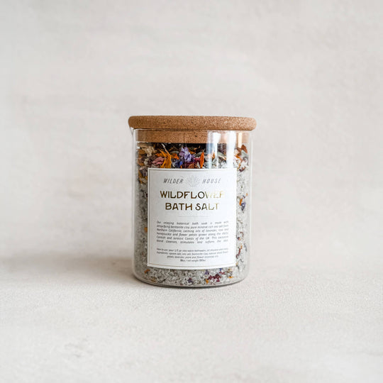 Jar of Wildflower Bath Salt with a wooden lid on a light background