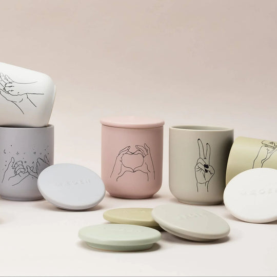 Set of ceramic containers with hand-drawn designs on a light background