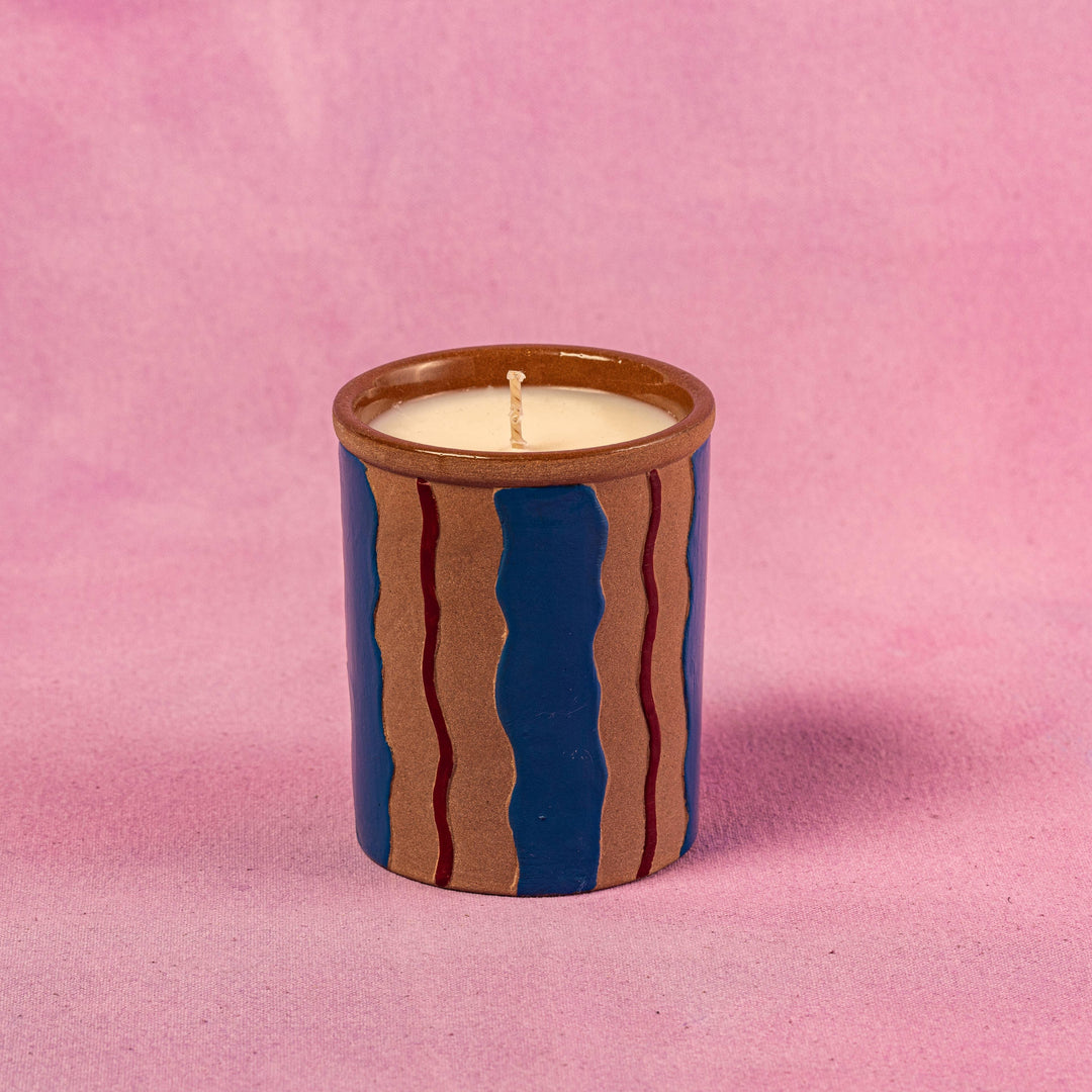 Ceramic candle with wavy design on a pink background
