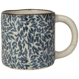 Ceramic mug with blue leaf pattern on a white background