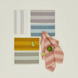 Set of striped fabric swatches with a pink and white striped towel on a light background