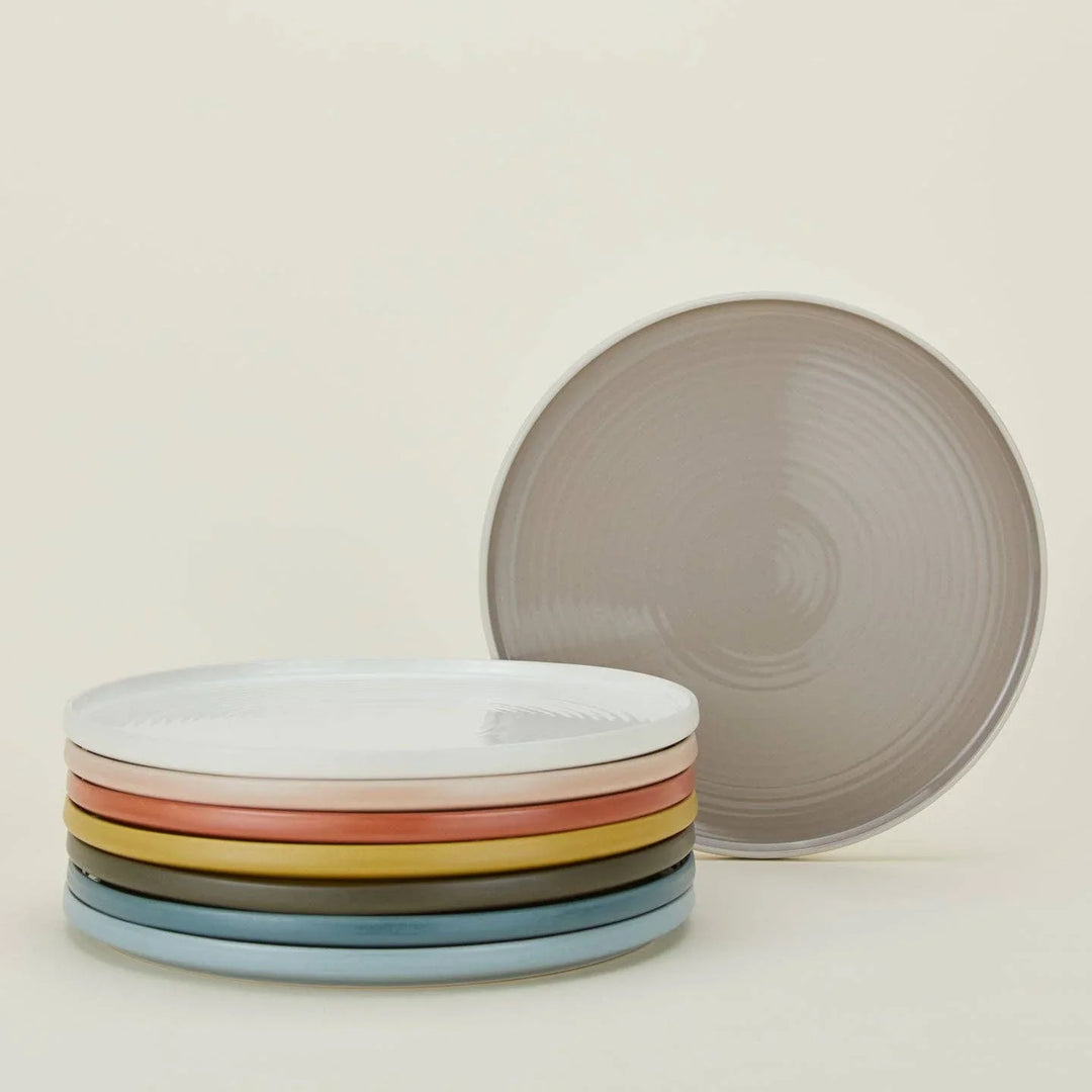 Stacked ceramic plates in pastel colors with textured design, ideal for modern table settings.
