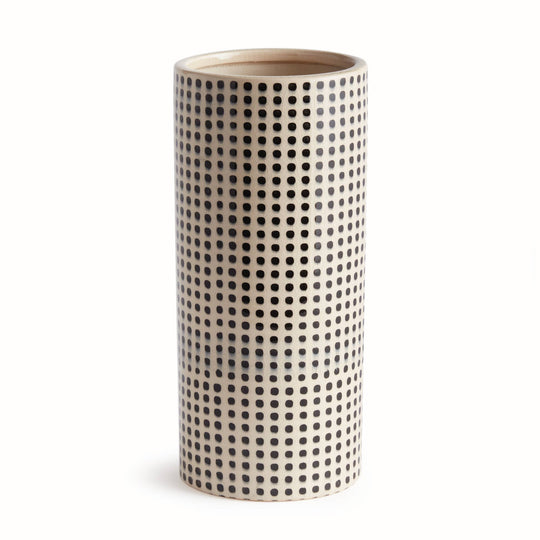 Cylindrical ceramic vase with black dot pattern on a white background