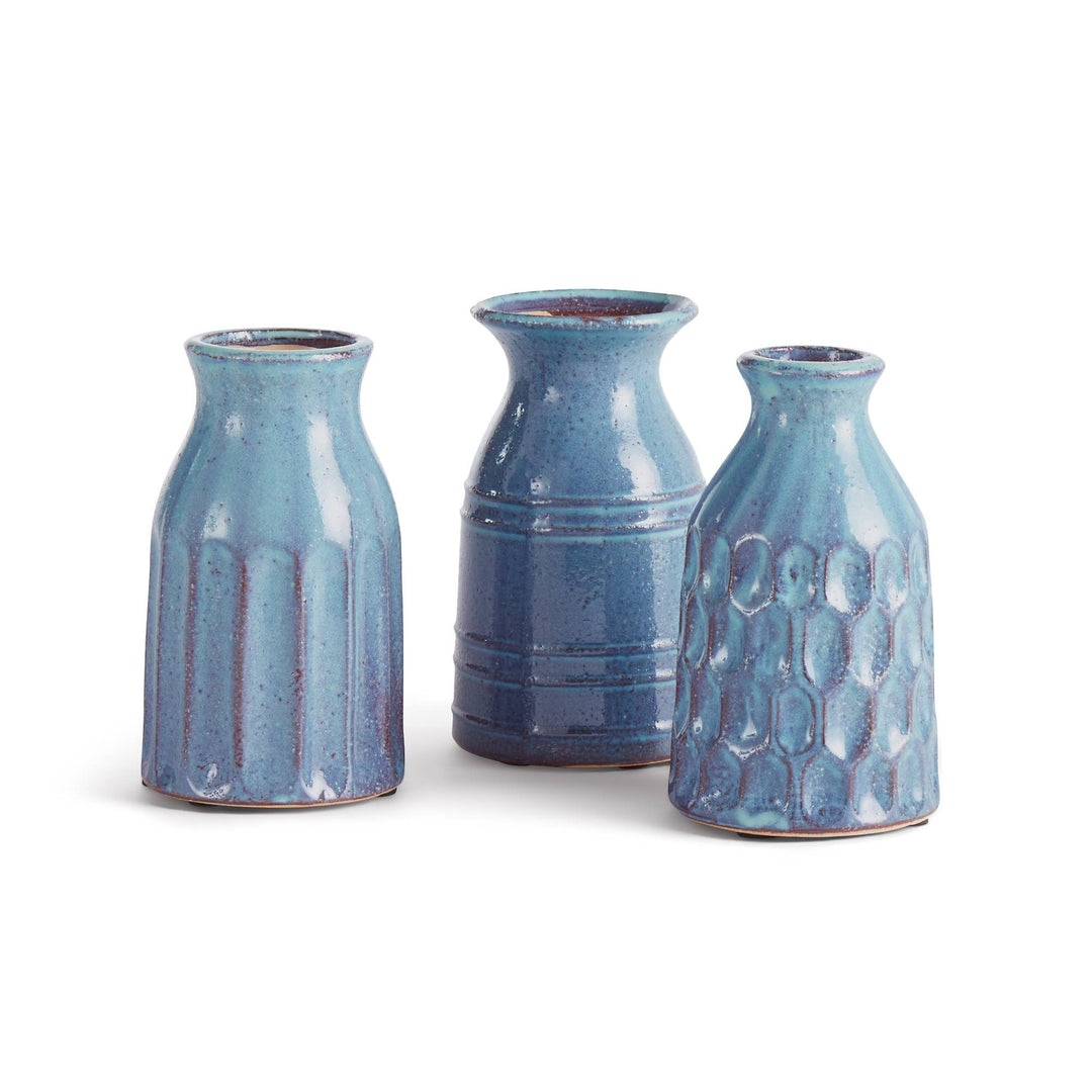 Three blue ceramic vases of different shapes on a white background