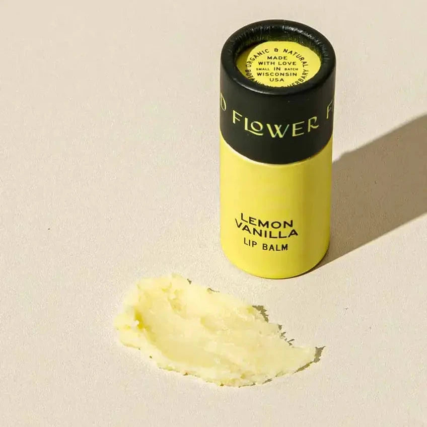 Lemon Vanilla lip balm with a visible brand name on a beige background