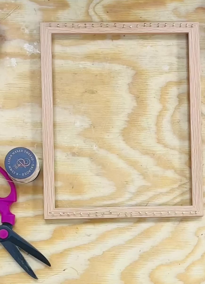 Video about weaving with flowers. Two hands creating a pattern with flax thread and weaving a selection of flowers into threads.