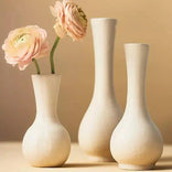 Elegant white vases with soft pink ranunculus blooms, perfect for fresh floral arrangements.