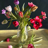 A picture of a glass vase with a mix of unique and special tulips in different colors.